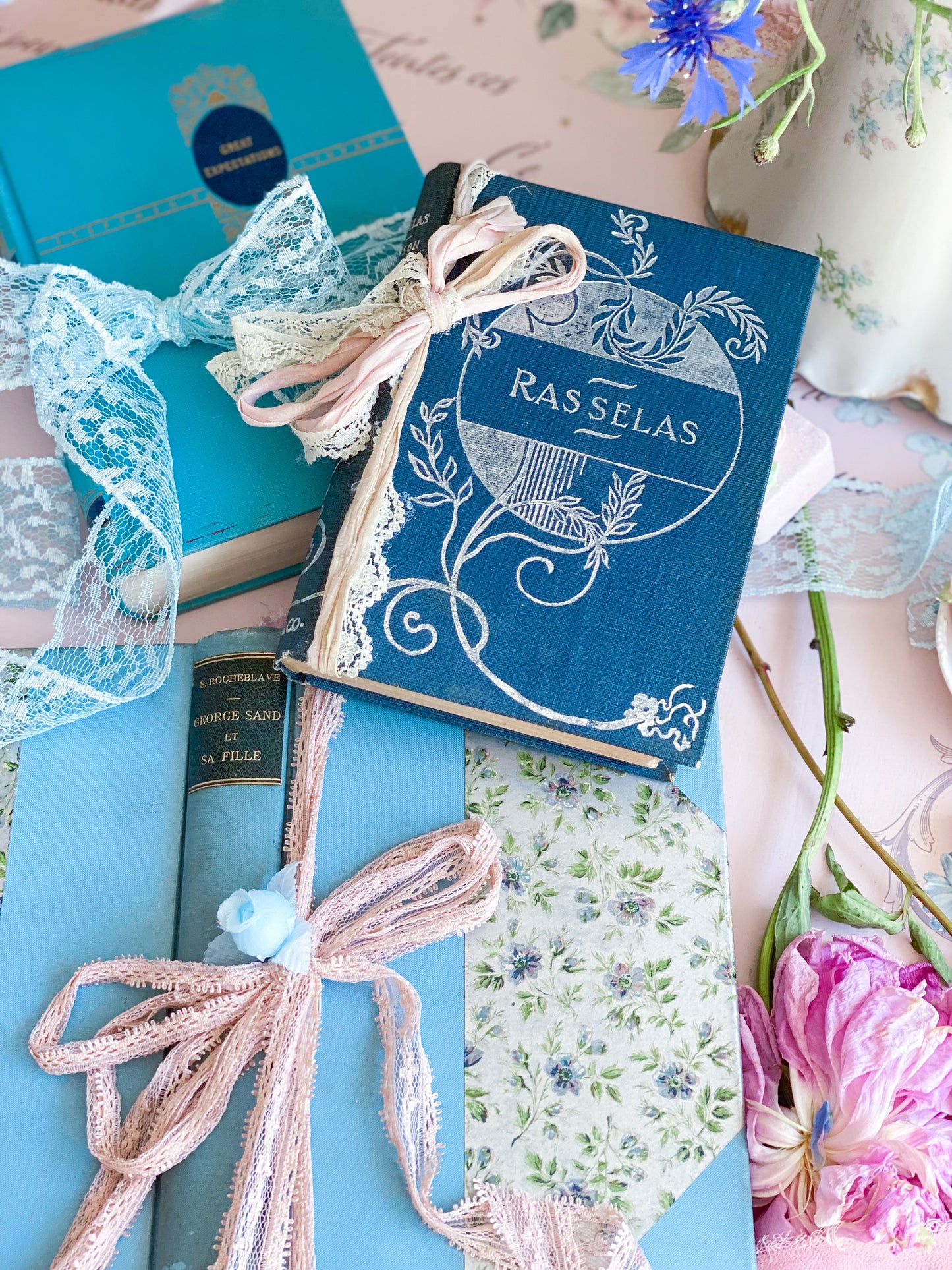 Set de 3 libros azules con tapas decorativas.