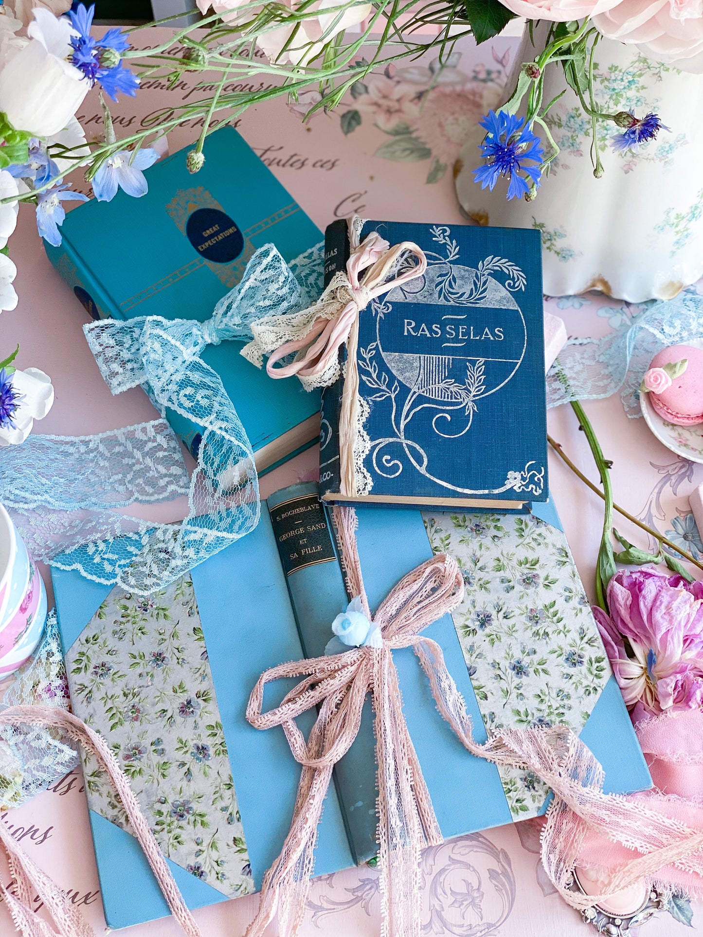 Set de 3 libros azules con tapas decorativas.