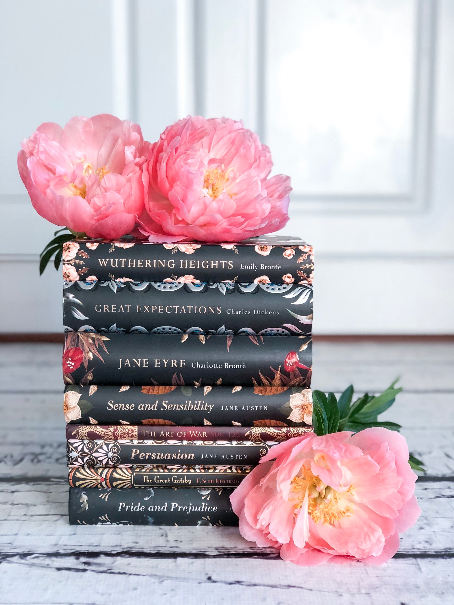 Peonías rosadas sobre lienzo envuelto en galería de pila de libros negros