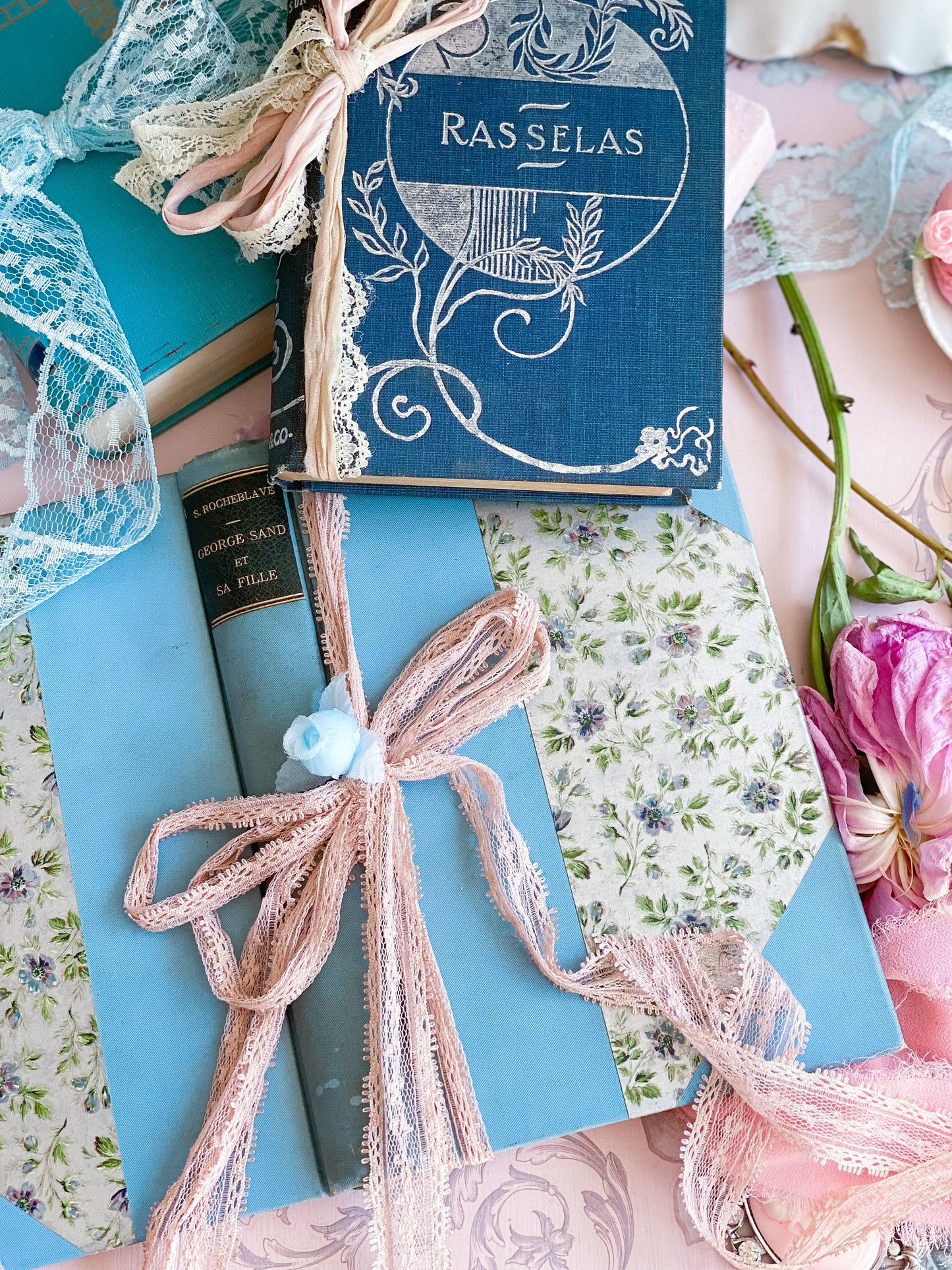 Set de 3 libros azules con tapas decorativas.
