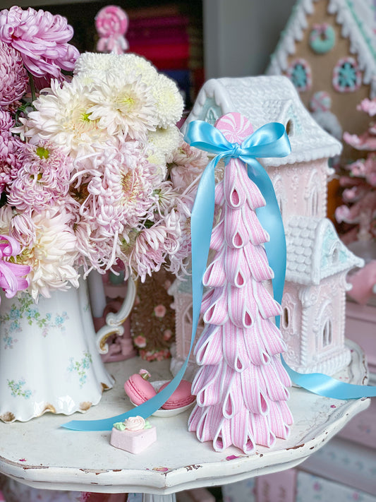 Árbol de dulces con cinta brillante rosa y blanca y lazo de satén azul