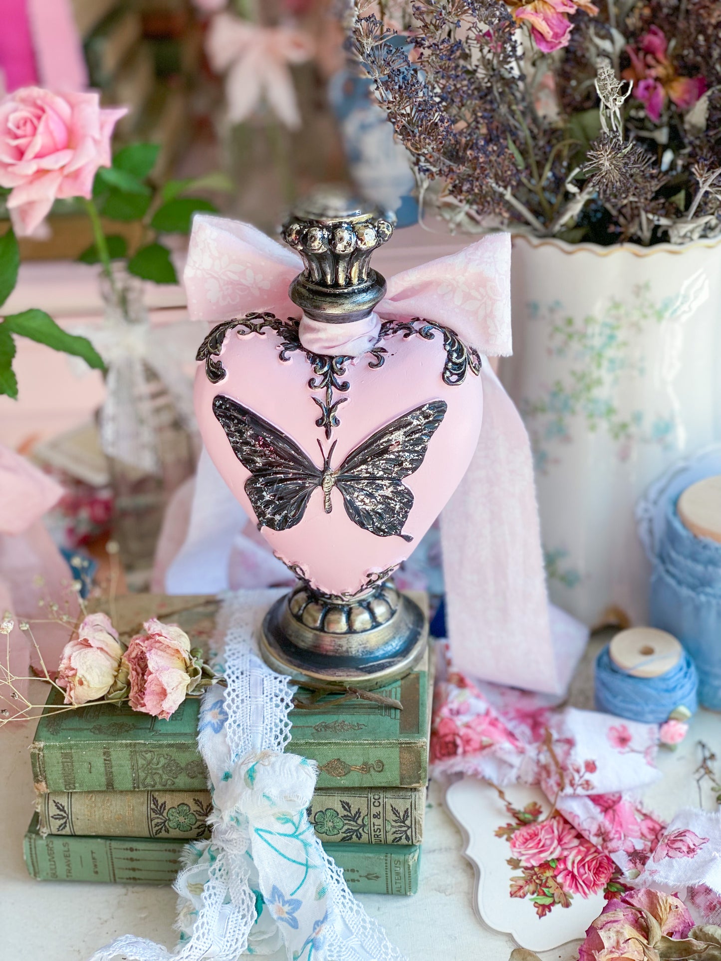 Botella de poción de mariposa en forma de corazón rosa con lazo