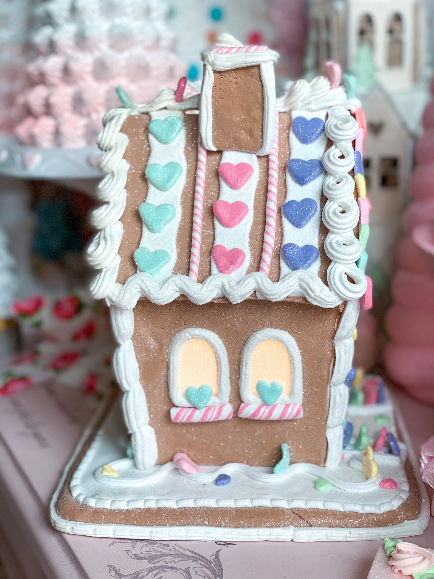 Pastellfarbenes, leuchtendes Lebkuchenhaus zum Valentinstag