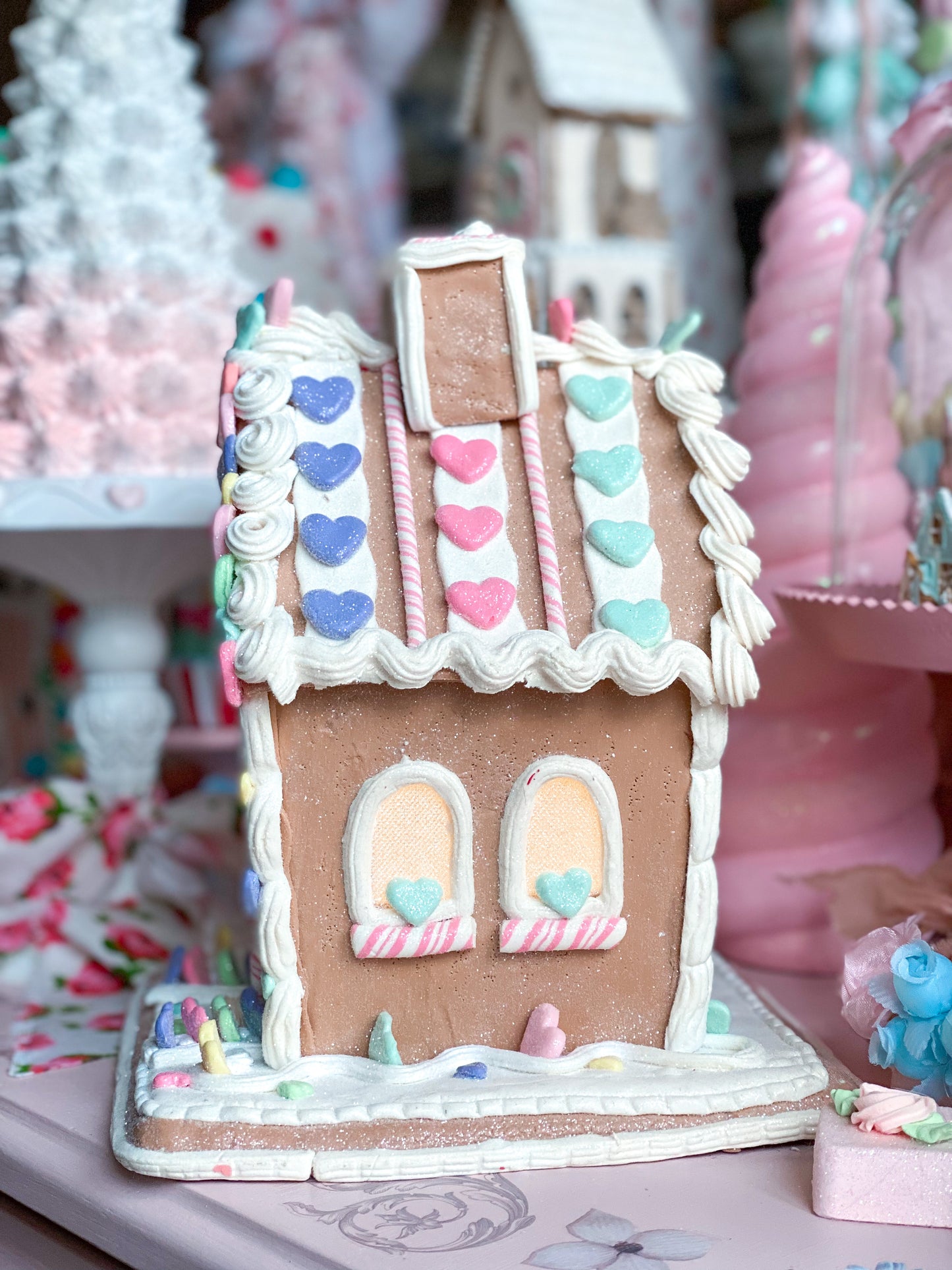 Pastellfarbenes, leuchtendes Lebkuchenhaus zum Valentinstag